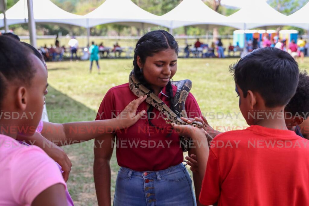 Cynara Baboolal, volunteer with El Socorro Centre for Wildlife Conservation, show off George the red-tail boa constrictor at the Project You Foundation National Children's Day, Queen's Park Savannah, Port of Spain. - Jeff Mayers