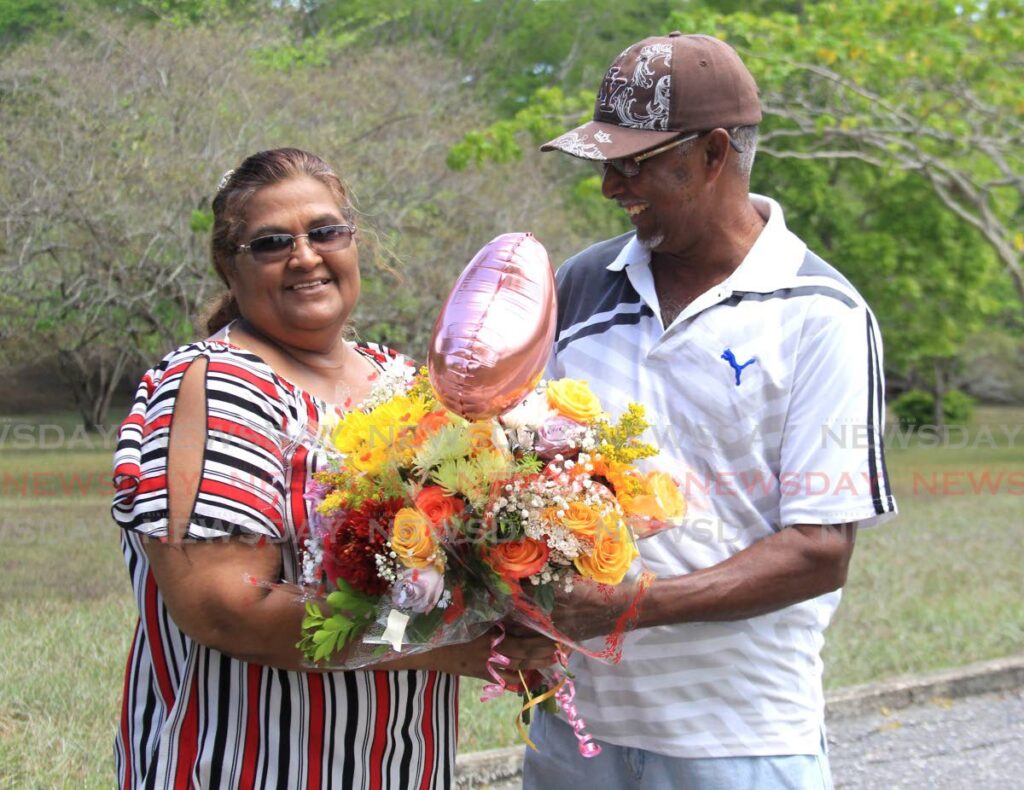 Dhanmatee Latchman is all smiles as her husband of 42 years gives her a bouquet of flowers for Mother's Day at Palmiste Park, San Fernando. 