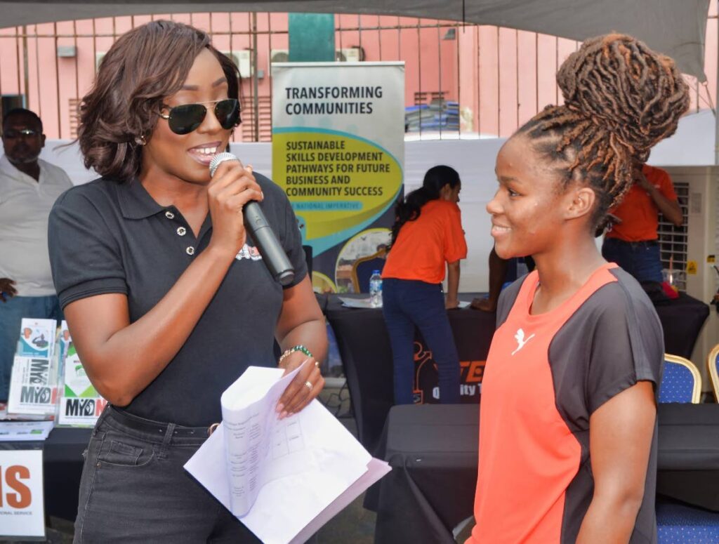 Model and host Athaliah Samuel, left, chats with  a Beetham resident  during the Ministry of Youth Development and National Service's Youth Career and Education Caravan held at the Beetham Community Center. - courtesy Overtime Media
