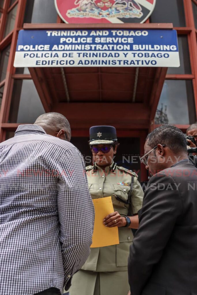 PRAYERS: Commissioner of Police Erla Harewood-Christopher prays with social activists Michael Kerr, left, and Andy Williams, right, after the two gave her a letter outside Police Administration Building in Port of Spain on Thursday. PHOTO BY JEFF MAYERS  - 