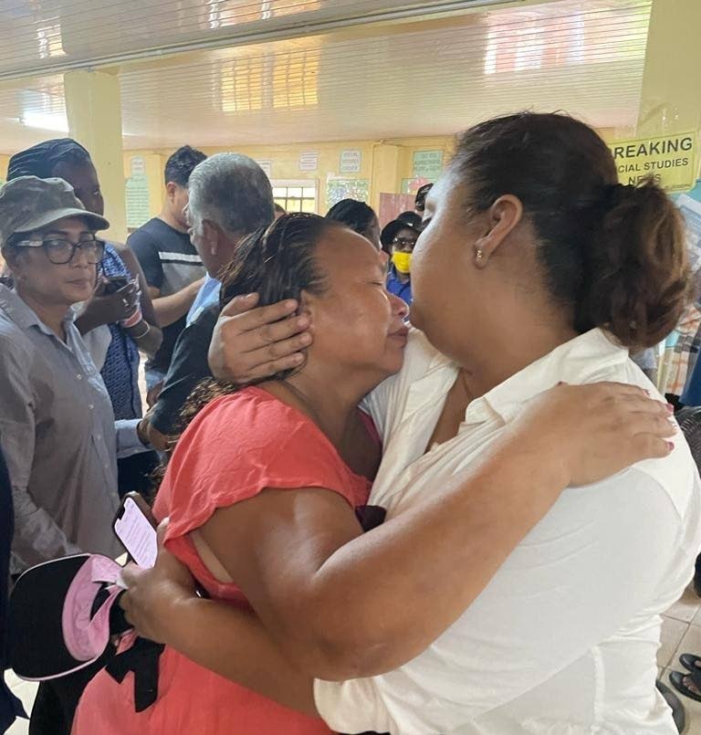 Carlette Williams, left, the house mother of the girl’s dormitory of the Mahdia Secondary School in Guyana is consoled by Guyana Minister of Education Priya Manickchand, after a fire in the dormitory killed over 19 people, including her five-year-old son, on Monday morning. Williams lived in the apartment attached to the dormitory. - Photo courtesy News Room Guyana
