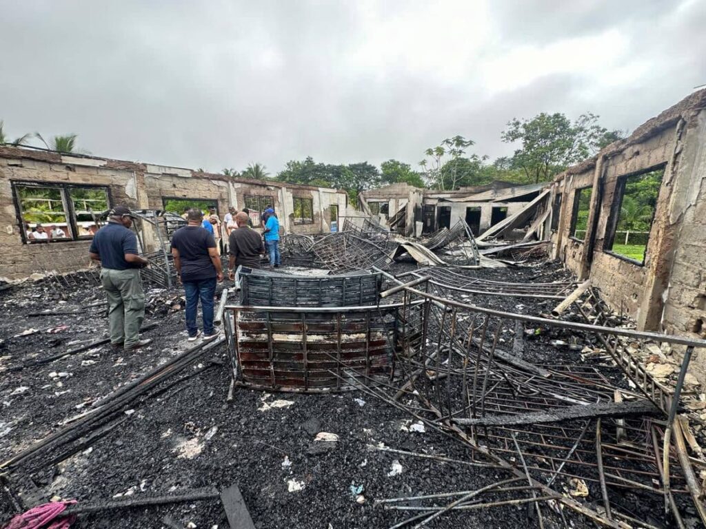 Police look for clues at the dormitory of the Mahdia Secondary School which was destroyed by fire on Monday in Guyana. - News Room Guyana