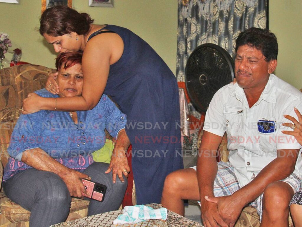 WEEPING PARENTS: Jean Mahadeo and her husband Suresh weep at their Sou Sou Lands, Carlsen Field home on Monday after their son Steven Suraj, was among two men shot dead on Sunday night in Palmiste, Chaguanas. PHOTO BY MARVIN HAMILTON - 