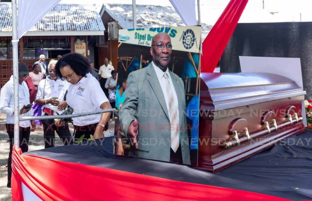 A portrait of former Pan Trinbago president Patrick Arnold rests on his coffin during a procession along Robinson Street before his funeral at Scarborough RC Church on Tuesday. PHOTO BY DAVID REID - 
