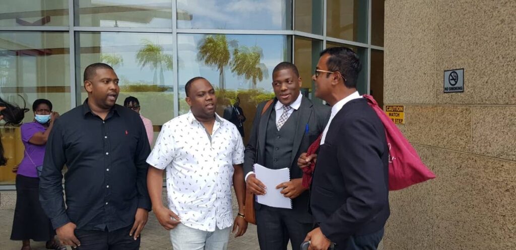 Beetham brothers Kevin, Kern and Kareem Marcelle speak to their attorney Larry Lalla, SC, at the Waterfront Judicial Centre, Port of Spain, on Wednesday. - 