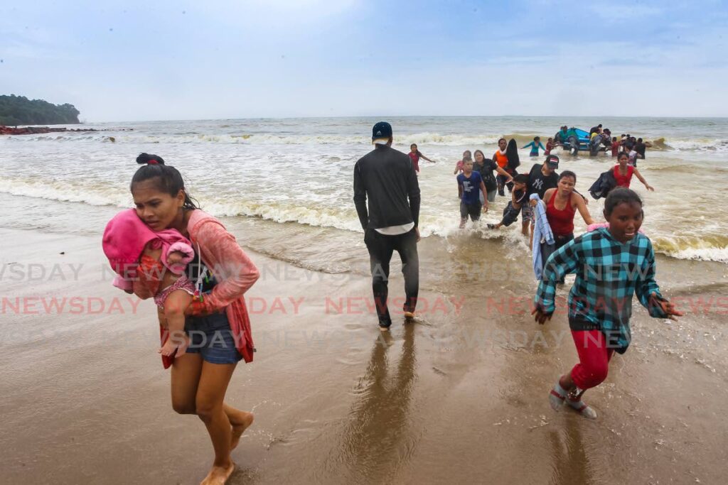 Migrants make their way to shore after disembarking  a pirogue after entering Trinidad illegally at Los Iros Beach, on November 24, 2020. - Lincoln Holder