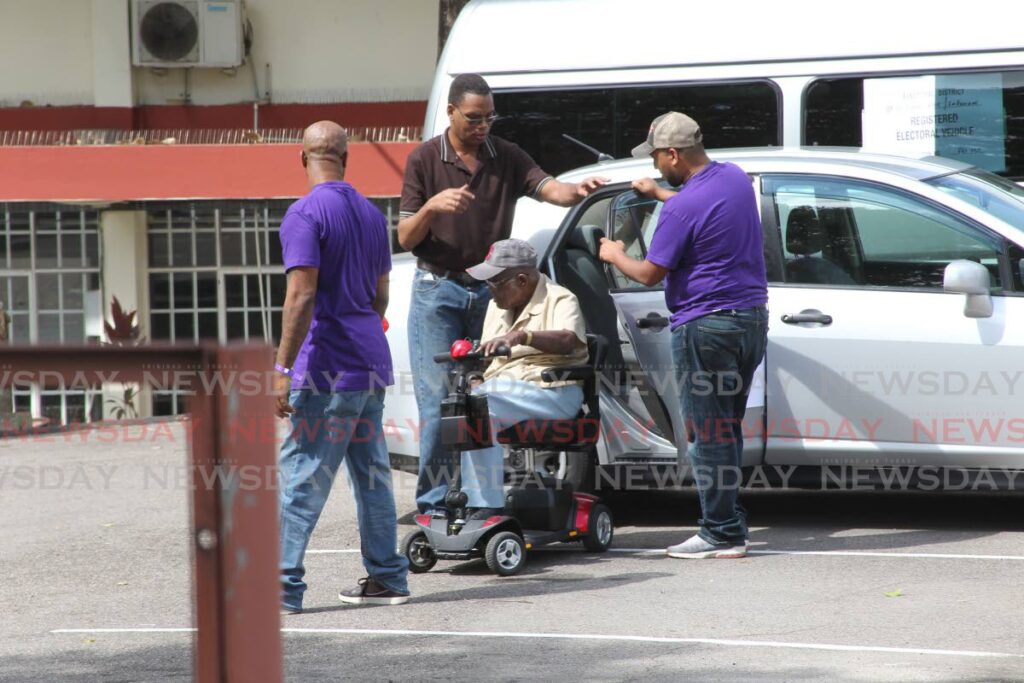 An elderly man gets help on his way to vote at San Fernando Central Secondary School in the 2016 local government elections. - 