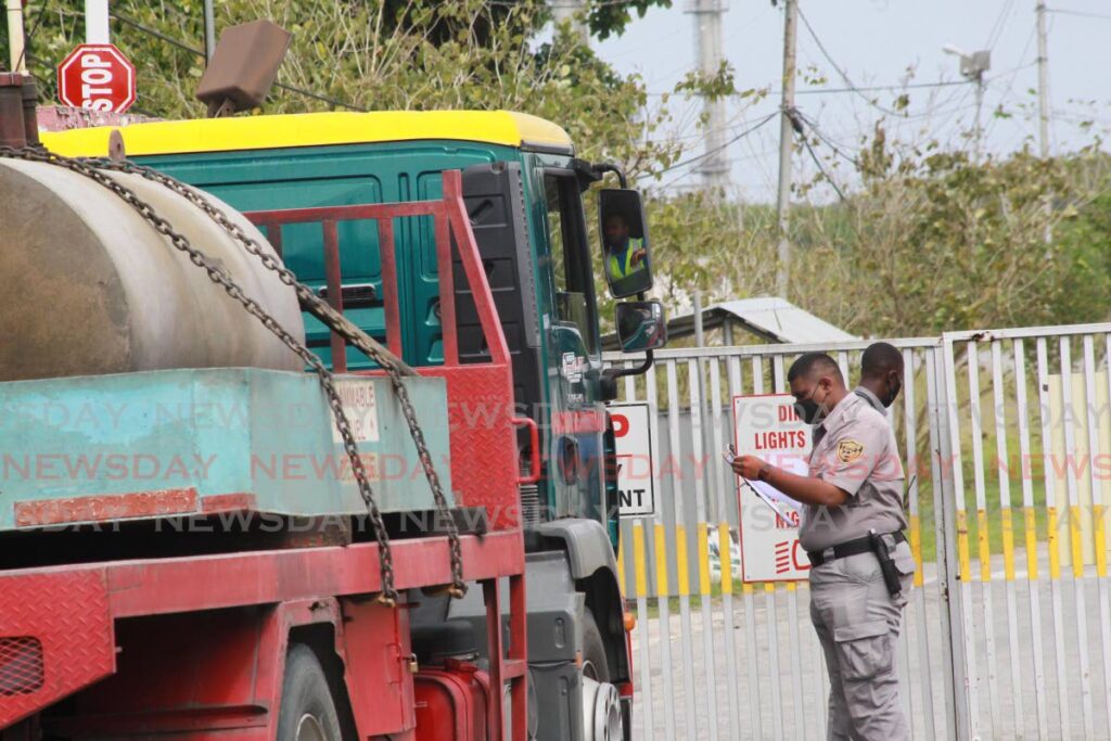 In this March 7, 2021, security officers screen vehicles arriving NiQuan Energy plant in Pointe-a-Pierre after an explosion at the site. - ROGER JACOB