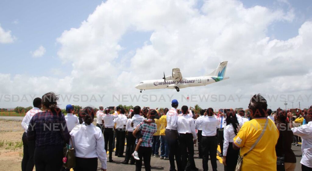 Onlookers view a Caribbean Airlines aircraft flypast during the launch of the UTT Avation Campus, Camden, Couva, on September 9, 2015. - 