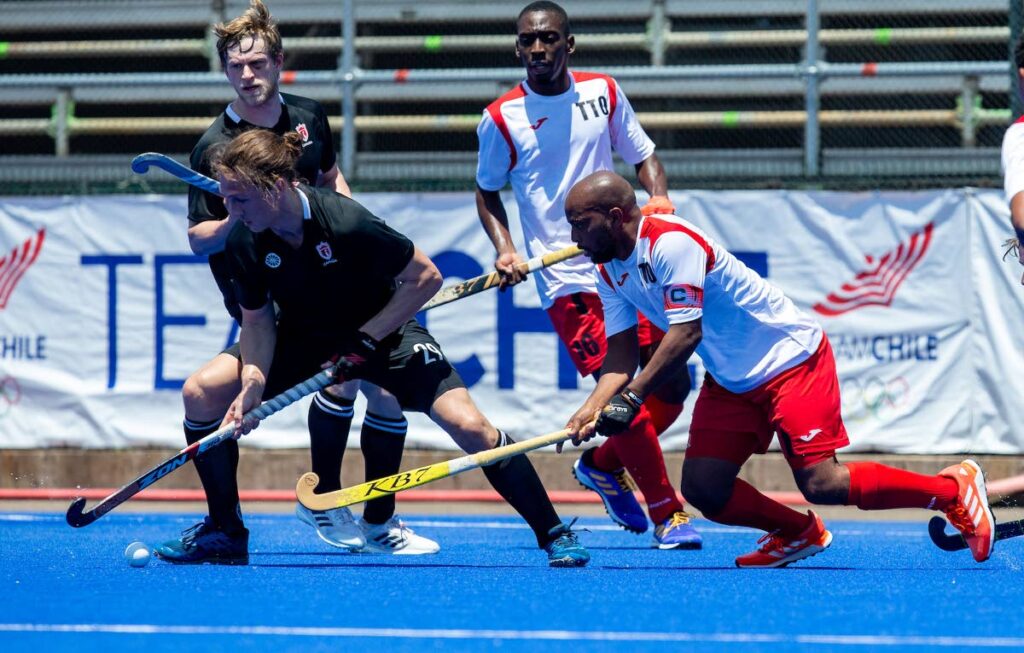 In this January 2022 file photo, TT’s men’s Akim Toussaint (R) vies for the ball against Canada’s Taylor Curran, during the Pan American Cup match, at Santiago, Chile.   - via Pan American Hockey Federation