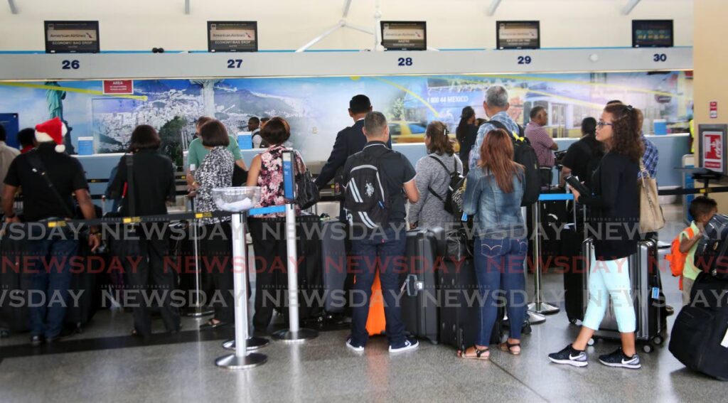 Passengers line up to check in American Airlines, Piarco Interational Airport in December 2017. File photo - 