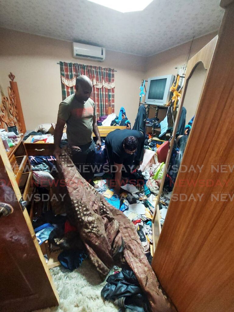 Michael Ramkhalawan and his wife Sharda in their ransacked bedroom on Friday, hours after the family house in Barrackpore was raided by bandits. PHOTO BY LINCOLN HOLDER - 