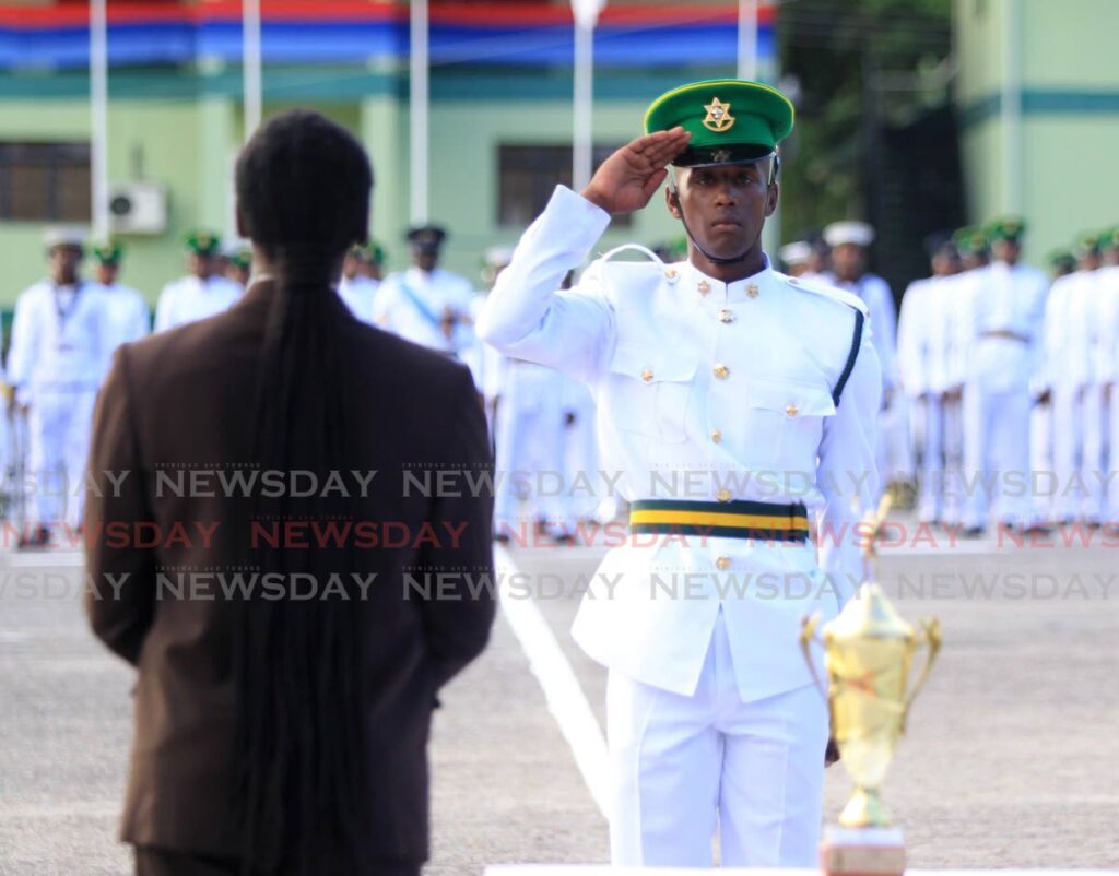 National Security Minister Fitzgerald Hinds is saluted by best male recruit T Bugros during the Defence Force passing-out ceremony at Teteron Barracks, Chaguaramas on Saturday. - AYANNA KINSALE