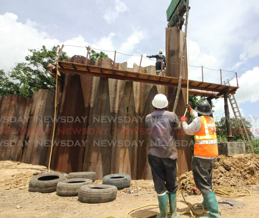 Steel beams and sheets are placed at the side of this landslip to reinforce the land during repairwork in Gasparillo on Thursday. PHOTO BY ANGELO MARCELLE - 