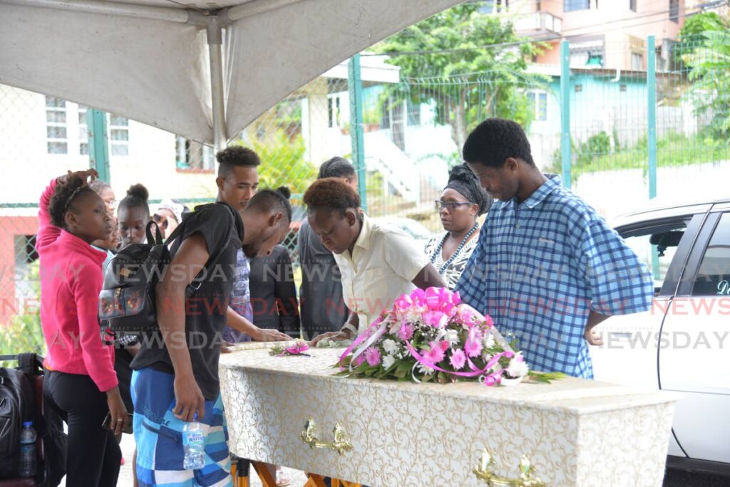 Family members of Gabrielle Raphael, congregate at her casket during her funeral at the Covigne Road Basketball Court, Diego Martin, on Friday. Gabrielle was found dead in the Queens Park Savannah, Port of Spain, on May 8 - Anisto Alves