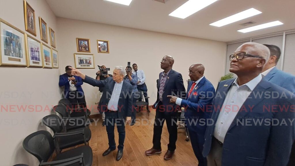 Finance Minister Colm Imbert, left, highlights photos on the history of the Diego Martin council to Prime Minister Dr Keith Rowley, centre, at the official opening of the Diego Martin Administrative Complex. At right is First Citizens chairman Anthony Smart, and at second right is Diego Martin Regional Corporation chairman Sigler Jack.
 - Jensen La Vende