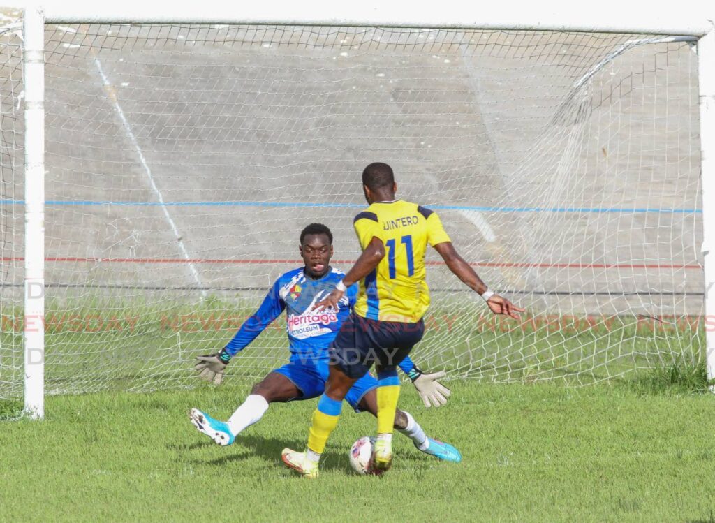 Dwight Quintero of Defence Force FC nutmegs Heritage Petroleum Point Fortin goalkeeper Tyrese Reefer, for the first goal of their Premier League match at the Arima Velodrome on Sunday. - Photo by Angelo Marcelle