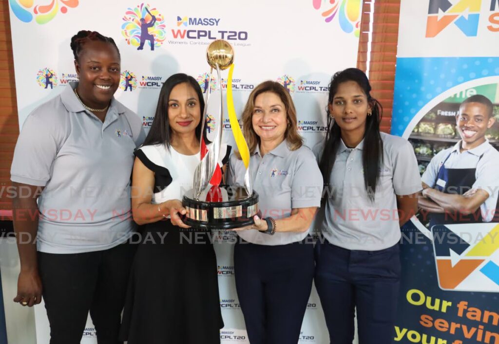 Ambikah Mongroo, second from left, Senior VP, Massy Group, holds the WCPL trophy with Natalie Black O'Connor, head, Branding and Hospitality, Massy, as West Indies players Lee-Ann Kirby, left, and Karishma Ramharack look on, at a press conference on Monday at President's Box, Queen's Park Oval, Port of Spain. - ROGER JACOB