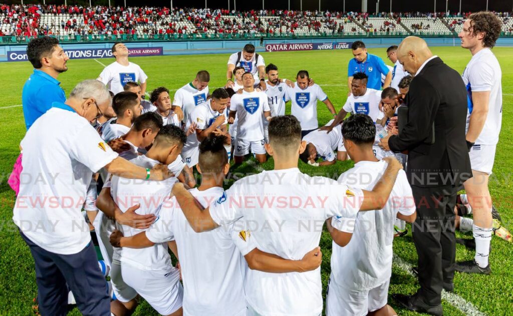Nicaraguan players and staff pray after their 1-1 draw with Trinidad and Tobago on March 27, 2023 at the Dwight Yorke Stadium, Bacolet, Tobago. - David Reid