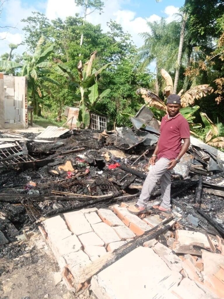 Kevon George stands in the burnt remains of his home at Chinese Village, La Brea, on Tuesday. The two-bedroom wooden house burnt down after it was struck by lightning on Sunday afternoon during heavy rain. - PHOTO COURTESY KEVON GEORGE