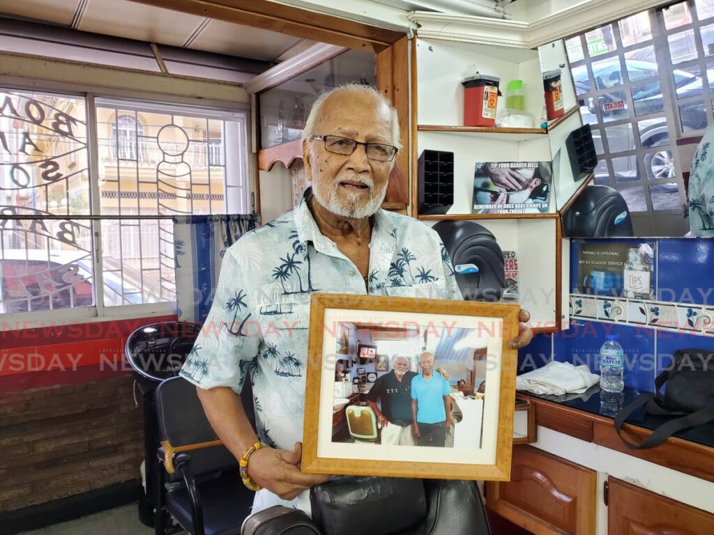 Basdeo Boney holds a picture of him and the late prime minister, Patrick Manning. - Vishanna Phagoo