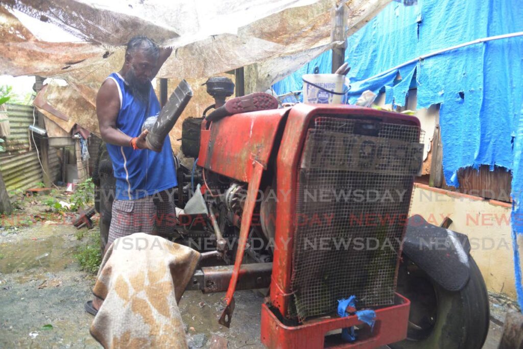 Kamraj Ramgollie uncovers the flood-damaged tractor he once used to move through floodwaters in St Helena, on Wednesday. - Anisto Alves