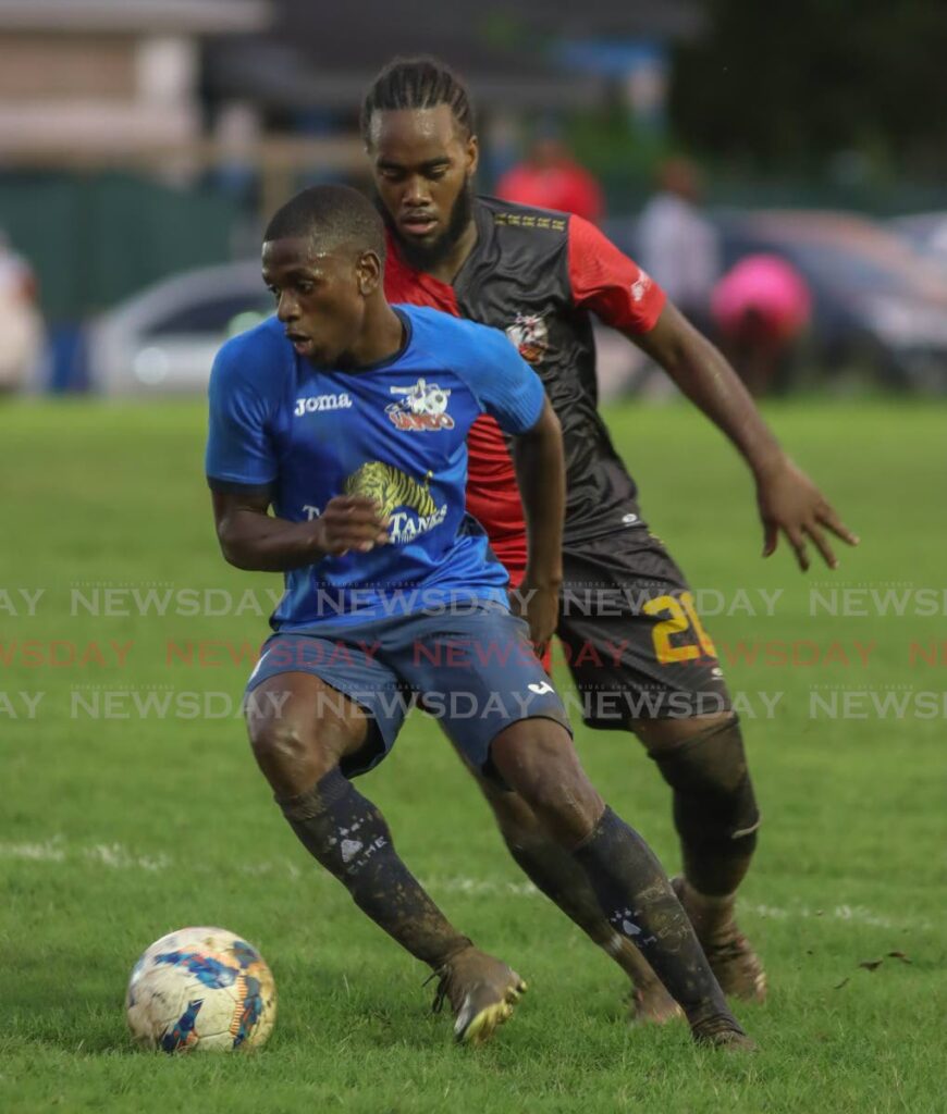 Kevon Williams, of Club Sando, dribbles past Che Benny of AC POS at the La Horquetta Recreation Ground, during their TT Premier League game on Wednesday.  - Angelo Marcelle