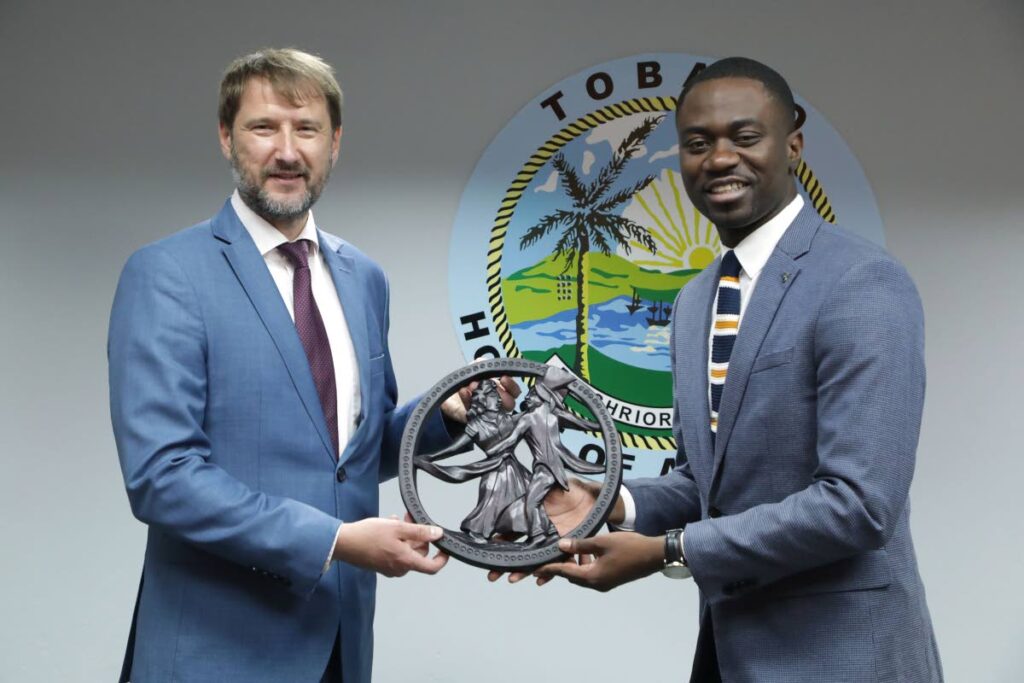 Chief Secretary Farley Augustine presents Latvia's undersecretary of state Andzejs Vilumsons with a sculpture – Old Time Wedding with Fiddler – by wood carver Collins Andrews-Toussaint of One Love Arts, during a courtesy call at Shaw Park Complex, Tobago on Friday. Photo courtesy THA Information Department - 