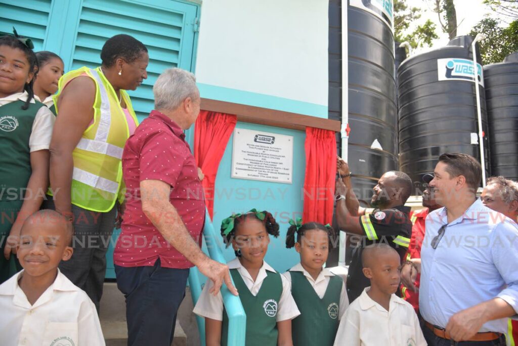 Public Utilities Minister Marvin Gonzales, second from right, unveils a plaque at the commissioning of the Mia Storage Reservoir, La Vigie, Paramin, with Communications Minister Symon de Nobriga, right, Finance Minister Colm Imbert and Planning and Development Minister Pennelope Beckles and schoolchildren on Saturday. - Anisto Alves