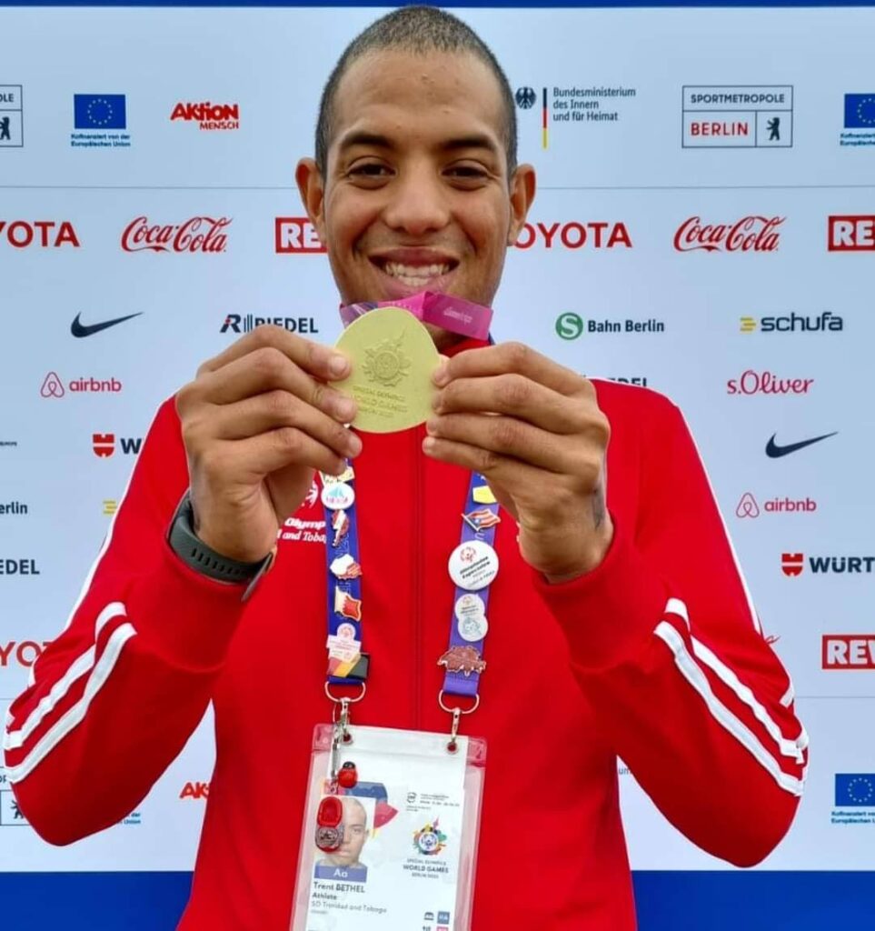 Swimmer Trent Bethel holds one of two gold medals he won at the Special Olympics in Berlin. - 