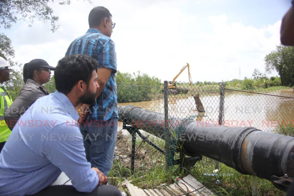 Director of drainage division Katherine Badloo-Doerga, from left, Works and Transport Minister Rohan Sinanan and minister in the ministry Richie Sookai look on as water is pumped at the Calco site, Penal on Saturday. - Lincoln Holder