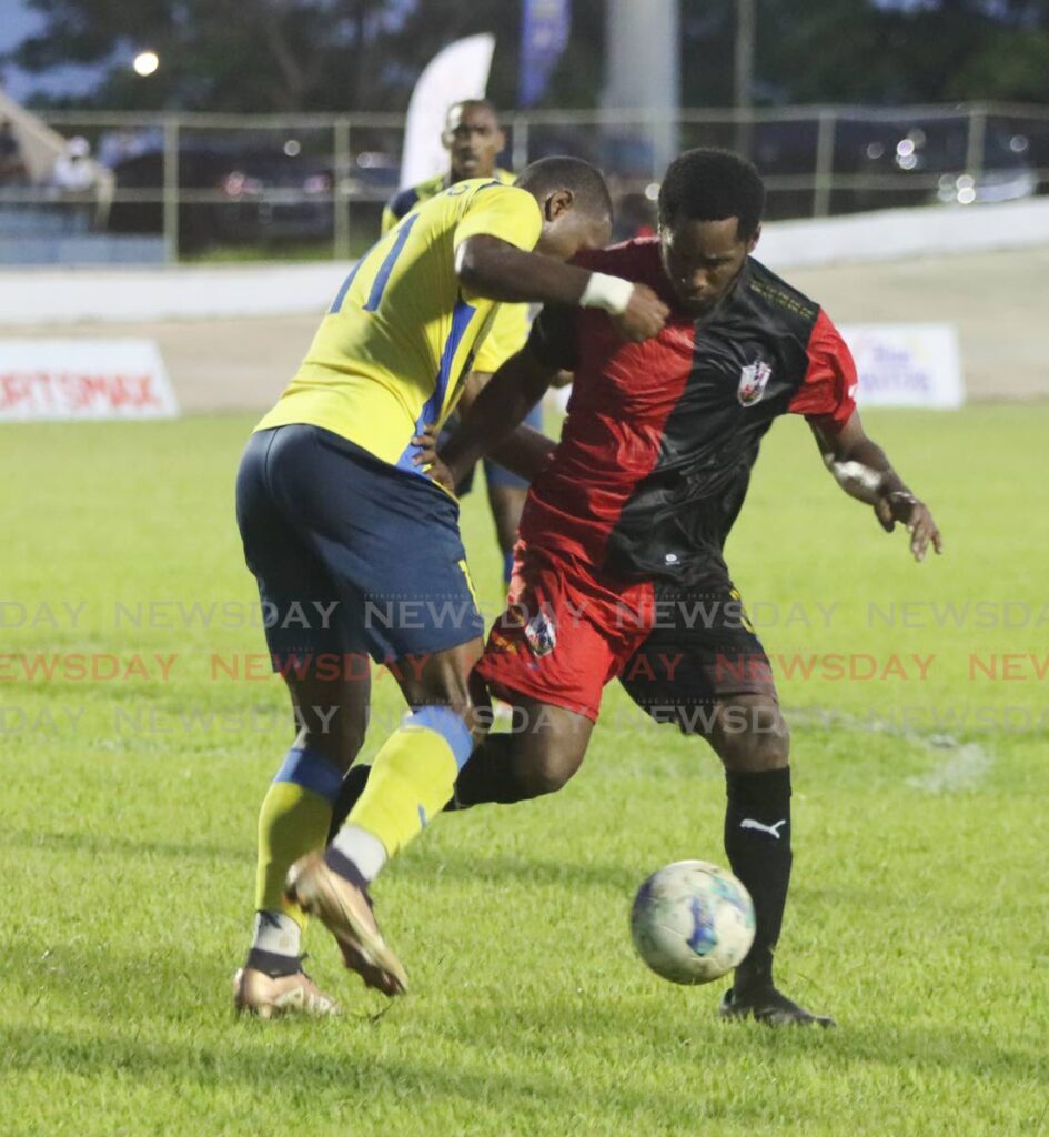Dwight Quintero (L) of Defence Force FC and Maurice Ford of Athletic Club PoS, challenge for the ball in the final of the TT Premier Football League at the Arima Velodrome, Arima on Saturday. - 