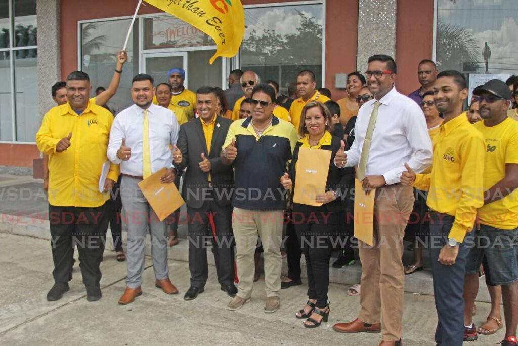 UNC Local Government candidates, Sheldon Lal, Shanty Boodram, Khemraj Seecharan and Raven Ramsawak pose for a photo alongside Oropouche West MP, Dave Tancoo and Oropouche East MP, Dr Roodal Moonilal, at the Shoppes of Debe where they filed their local government nomination papers.  - Photo by Lincoln Holder