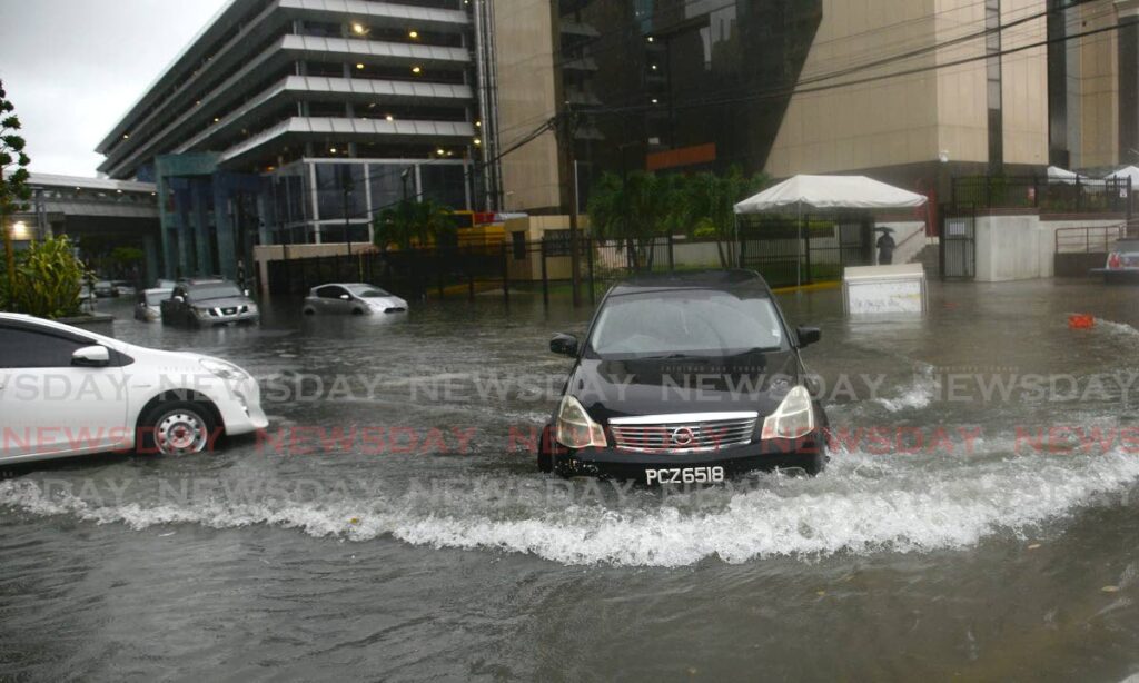 A vehicle drives through the flooded Independence Square, Port of Spain on Tuesday.