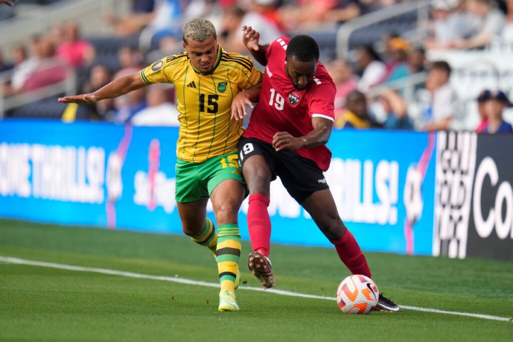 Jamaica’s Joel Latibeaudiere (L) and TT’s Malcolm Shaw battle for the ball during the first half of a Concacaf Gold Cup match on Wednesday, in St. Louis. Jamaica won 4-1. - AP PHOTO