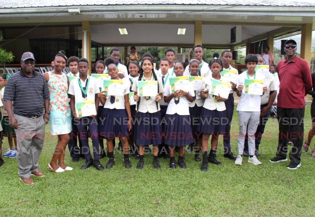 FUTURE GOLFERS: Students of Mucurapo West Secondary display their certificates as they pose for a photo with golf trainers Stephen Bishop, left, and Carlos Beckles, right, at the closing ceremony of the CDA Junior Golf programme on Friday at the Chaguaramas golf course in Tucker Valley. PHOTO BY AYANNA KINSALE  - 