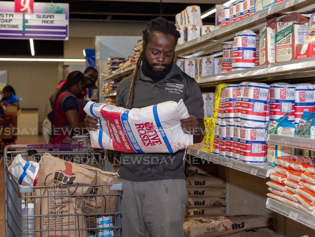 Hasani George of Whim, Tobago buys four sacks of flour at Penny Savers, Carnbee, Tobago - File photo/David Reid