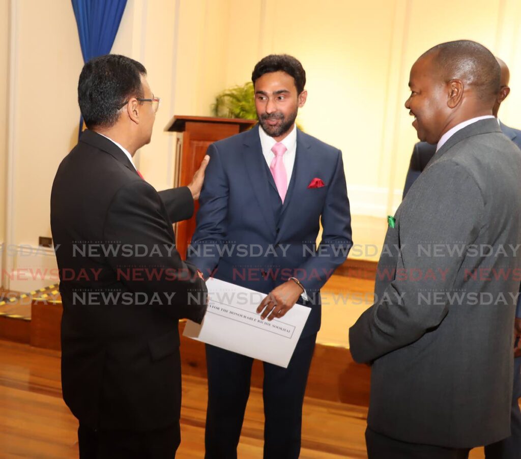 Richie Sookhai, centre, congratulated by Works and Transport Minister, left, on his a appointment as a minister in the ministry at President's House on April 13. At right is Foster Cummings, Youth Development and National Service Minister. - ROGER JACOB