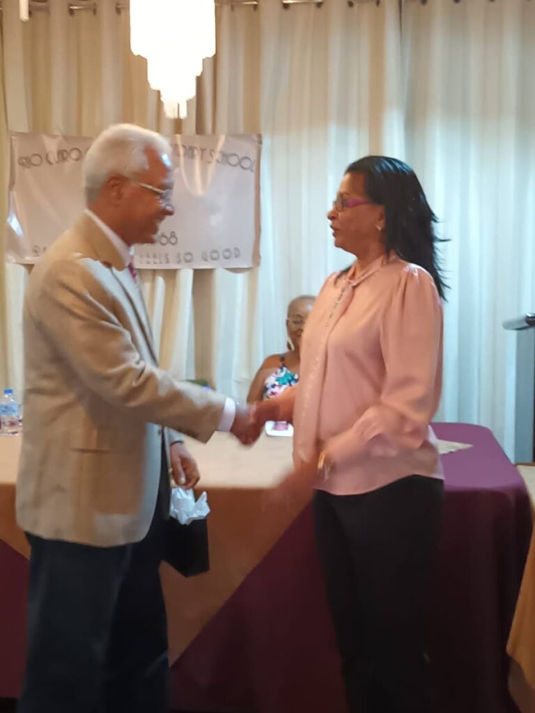 Maureen Sookdeo makes a presentation to chairman of the Fair Trade Commission Dr Ronald Ramkissoon who graduated from the Rio Claro Government Secondary School in 1970. - 