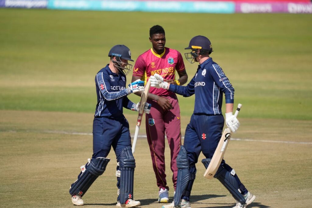 West Indies pacer Alzarri Joseph (C) looks on as Scotland's Mathew Cross (L) and Brandon McMullen touch gloves during their ICC Men's Cricket World Cup Qualifier match at Harare Sports Club in Harare, Zimbabwe, on Saturday. - AP PHOTO