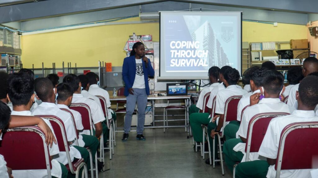 Former Global Peace ambassador Kareem Daniel Ryce engages with male students of the Carapichaima East Secondary School. - 