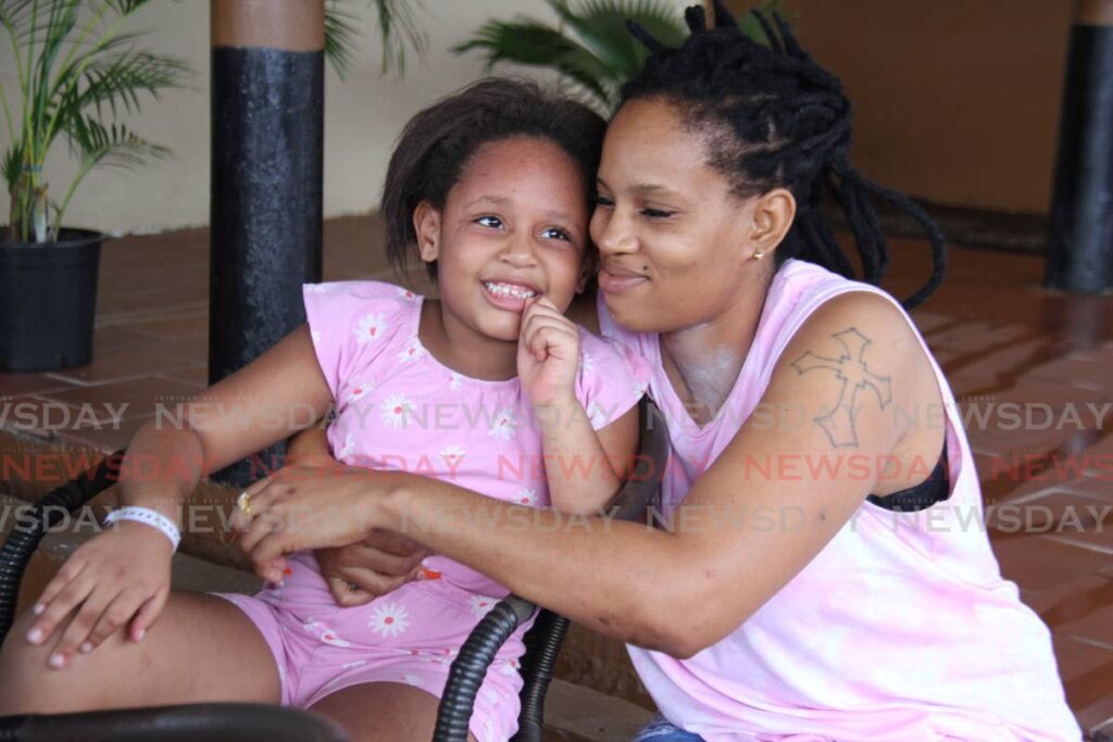 MIRACLE BABY: Marina Murray hugs her daughter Jenysa Alleyne, five, at a relative's home in Point Fortin after she was discharged from the Siparia District Health facility, on Sunday. - AYANNA KINSALE