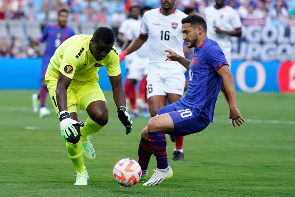TT goalkeeper Marvin Phillip blocks a shot by United States midfielder Cristian Roldan during the first half of a Concacaf Gold Cup Group A match on Sunday, in Charlotte, N.C - AP PHOTO
