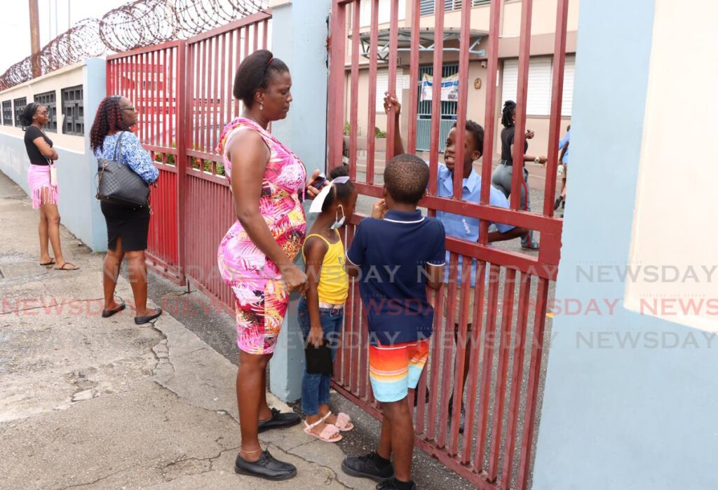 FINALLY: Aeshalaun Toussaint, right, speaks to his mother Keisha after finally getting his SEA exam results at the Richmond Street Boys’ Anglican Primary School on Monday. PHOTO BY ANGELO MARCELLE - 