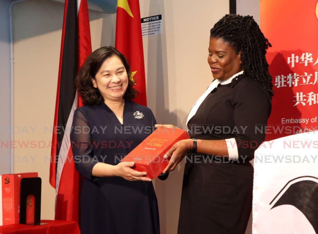 China's assistant Minister of Foreign Affairs Hua Chunying presents a digital book to Nalis executive director Paula Greene on Monday  - Photo by Angelo Marcelle