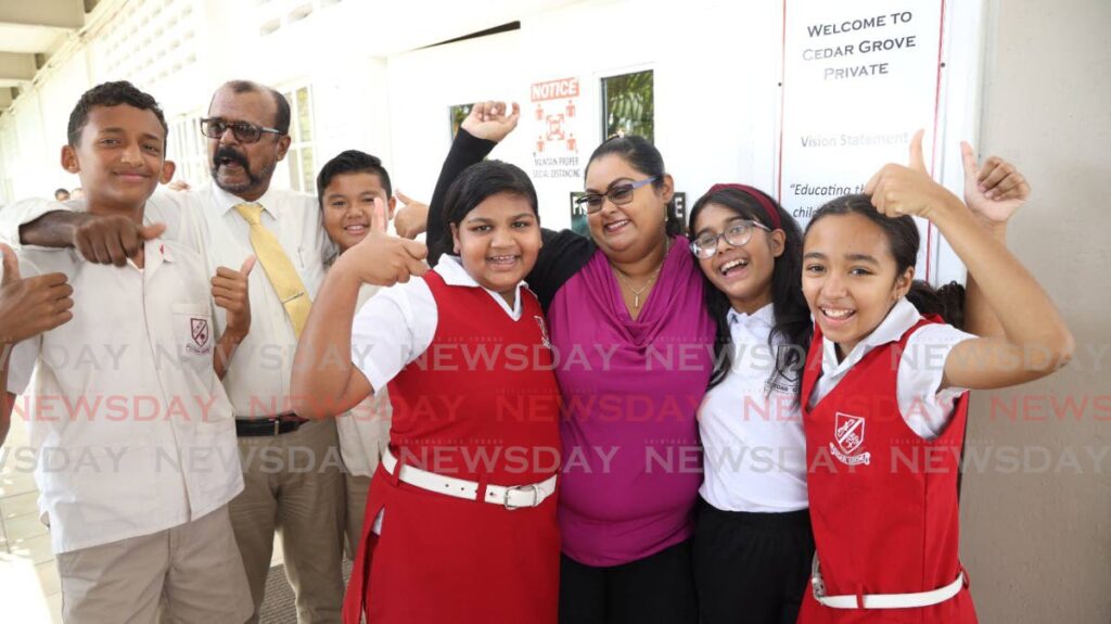 HAPPY FACES: Shaheed Allaham, 2nd from left, Principal of the Cedar Grove Private Primary School, together with a teacher, celebrates with these SEA students who got their results on Monday afternoon. PHOTO COURTESY CEDAR GROVE PRIVATE PRIMARY SCHOOL - 