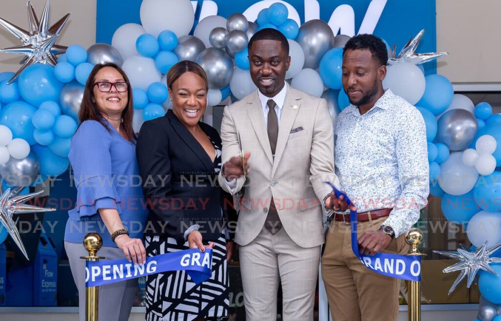 Ribbon Cutting: Farley Augustine, center, Chief Secretary, Tobago House of Assembly, had the privilege of cutting the ribbon declaring Flow's retail Store at #2 Milford Bay Plaza, Crown Point, Tobago opened on Monday. - Photo by David Reid
