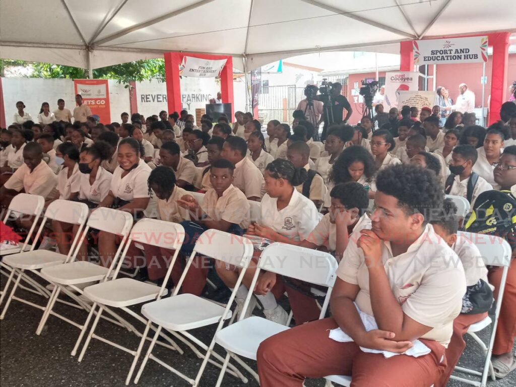 Students of Arima Central Secondary School listen during the  I Choose Sport TT School Caravan at the school's compound on Thursday. - Jelani Beckles