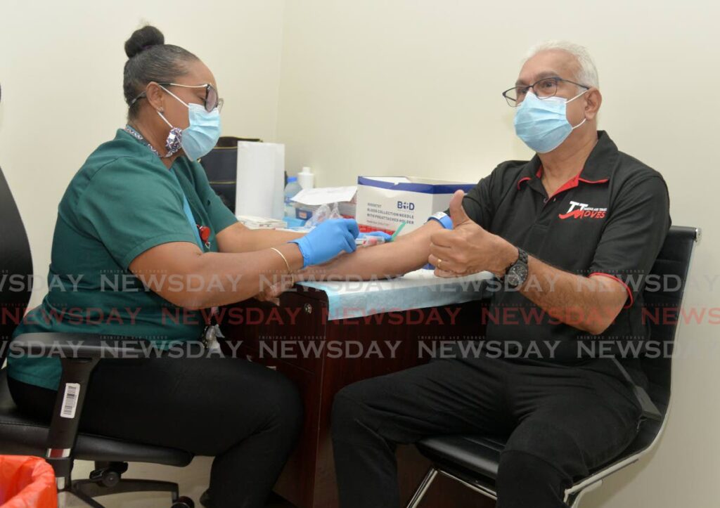 Phlebotomist Stacy Charles collects blood from Health Minister Terrance Dyalsingh for a PSA test which screens for prostate cancer during the Health Ministry’s Its All About Him: A Health Initiative for Men at the Mt Hope Women’s Hospital, on Saturday. - Anisto Alves