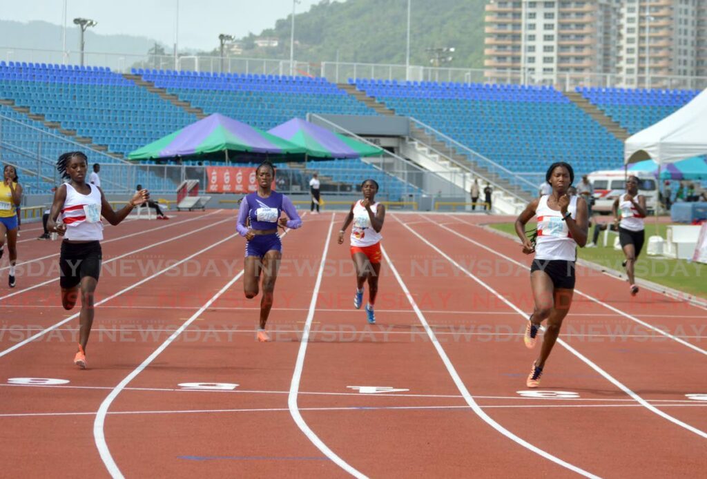 Kaziah Peters (R) wins the Girls’ Under-18 200m semi-final, on Sunday, during the NAAATT Junior Championsips, at the Hasely Crawford Stadium, Port of Spain.  - Anisto Alves